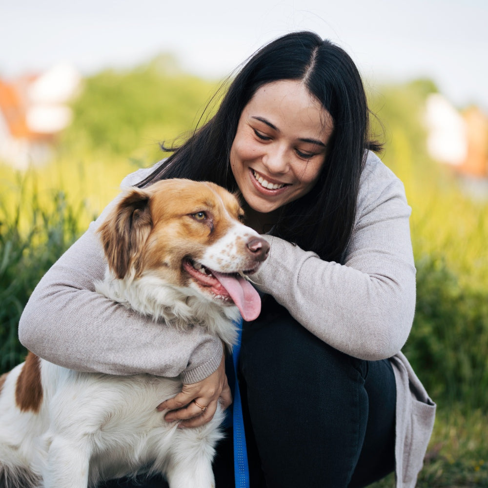 happy dog owner cuddling dog